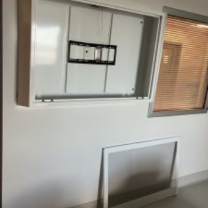 Anti-ligature TV enclosure being installed in a behavioral health patient room