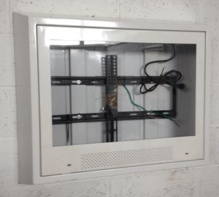 Large 65 inch anti-ligature TV enclosure installed in behavioural health facilities recreational rooms